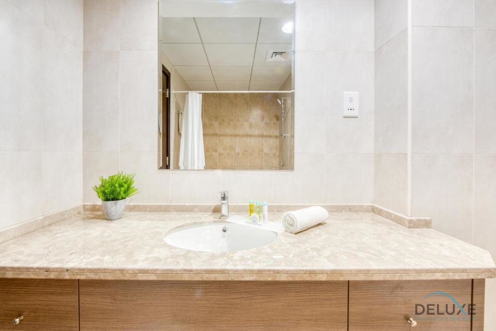 Дубай: Sunny 1BR at Canal Residences West Dubai Sports City by Deluxe Holiday Homes
